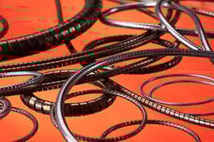 Coiled film reels are scattered on a vibrant orange surface, creating a dynamic, artistic arrangement. The image evokes a sense of nostalgia and creativity.