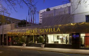 Exterior view of the Meliá Sevilla hotel at dusk.
