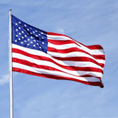 American flag waving against a blue sky.